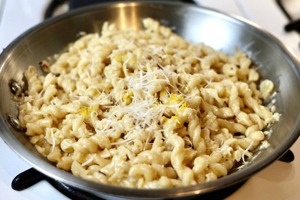 Gemelli with cheese in a frying pan on a stove
